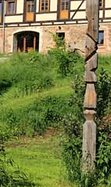 Der echte historische Vierseithof in Niedermuschütz — Fachwerk, handgeschnitzter Holzpfahl und wilde Wiese, Ort der Innenwelt-Begleitung und Auszeit